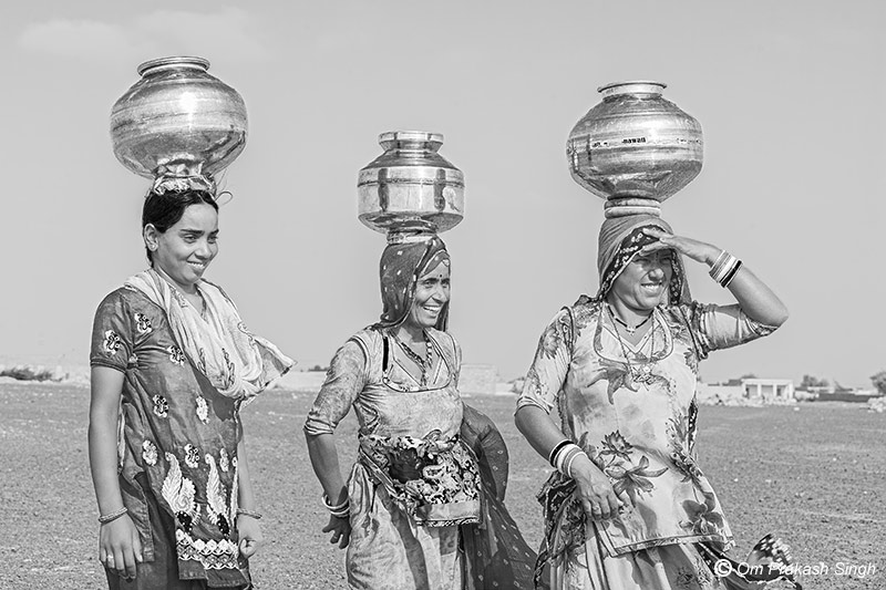 Joyfully returning home with pitchers full of drinking water from Viprasar pond in Netsi village, Thar Desert, Jaisalmer, Rajasthan, India